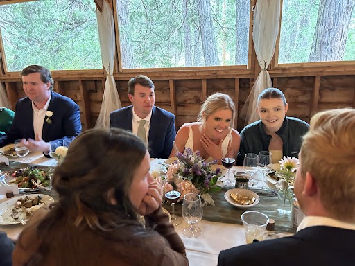 Bride and Groom with guests seated and dining in the Gold Lodge