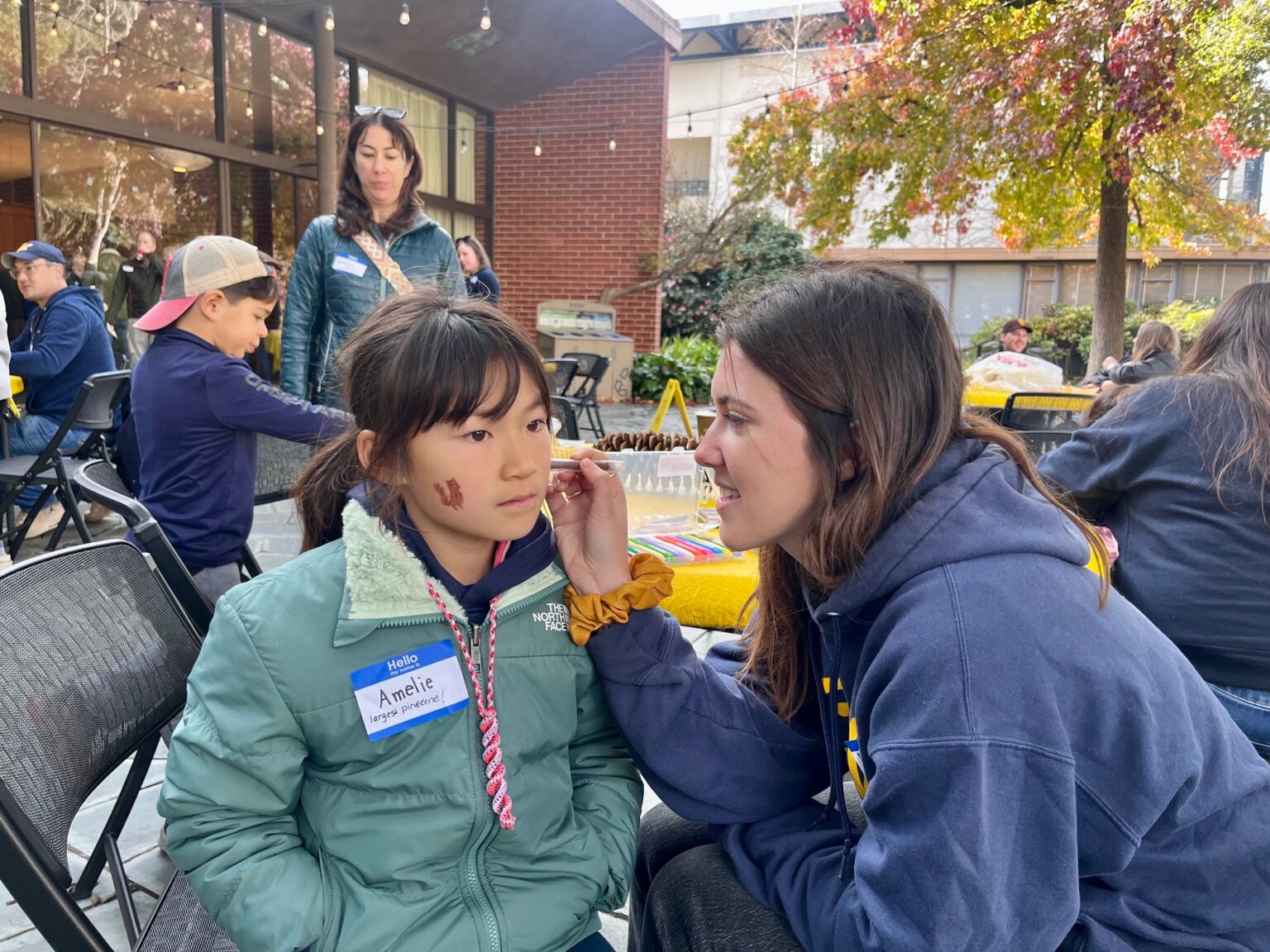 A young girl getting her face painted by a Lair staffer