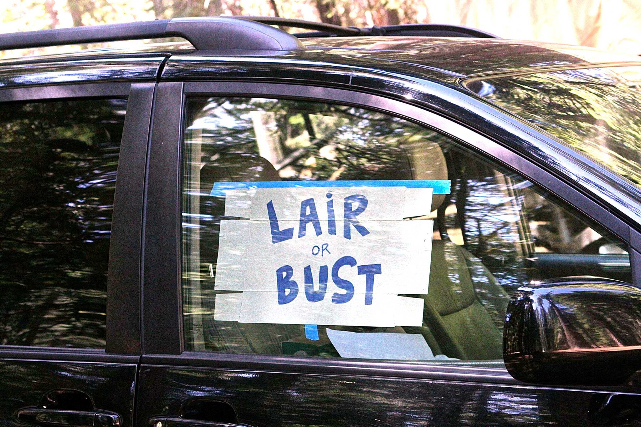 sign in car window reads lair or bust