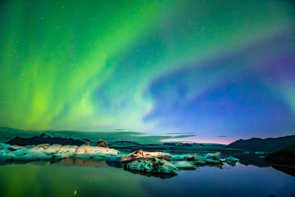 A green and purple northern lights over water