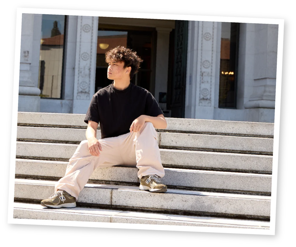 Gavriel Curameng seated on steps at the UC Berkeley campus